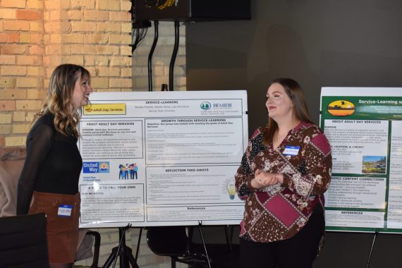 Two people presenting a poster