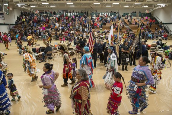 Pow wow at Bemidji State in 2019, with many people in Indigenous clothing dancing in a gymnasium