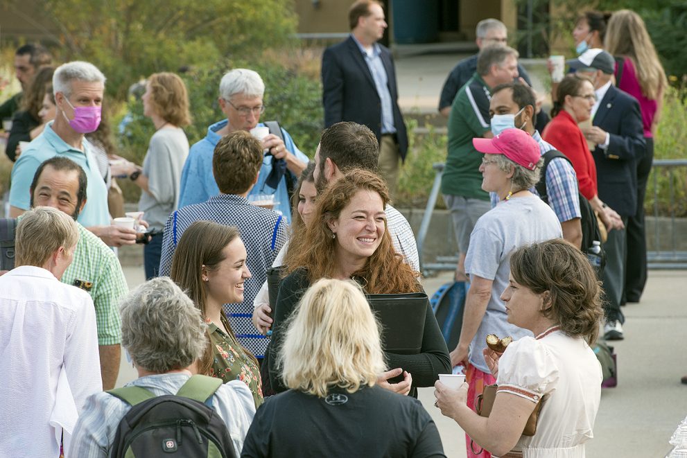 Campus members gather outdoors for a breakfast social