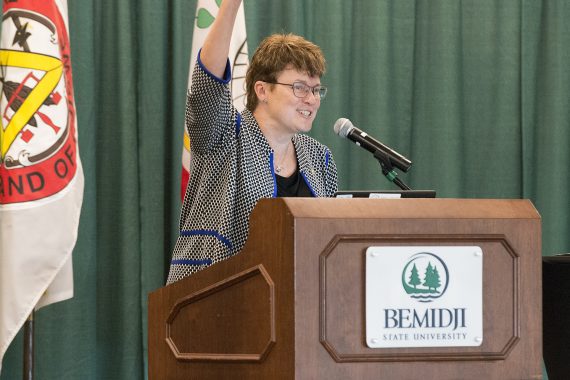 President Faith C. Hensrud with her arm in air saying Go Beavers