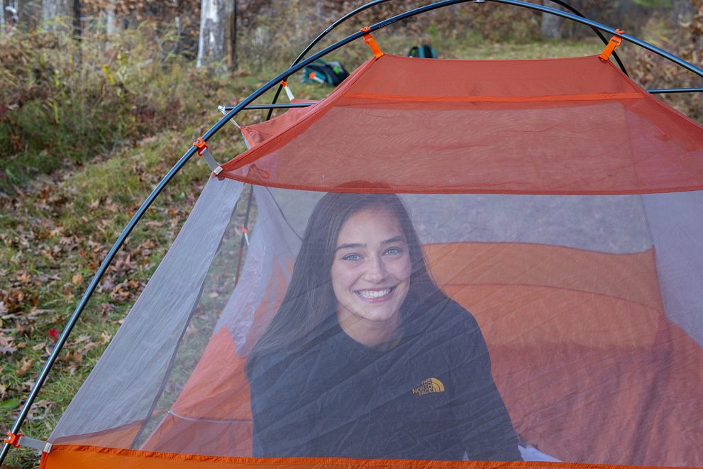 A student setting up a tent