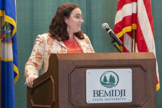Elizabeth Burud, standing at a podium and addressing the BSU nursing class of 2024