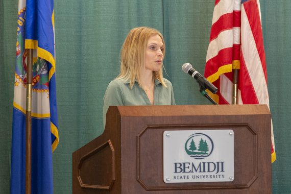Rachel Vesta, assistant professor of nursing, standing at a podium and discussing the purpose of induction into Bemidji State University's Department of Nursing