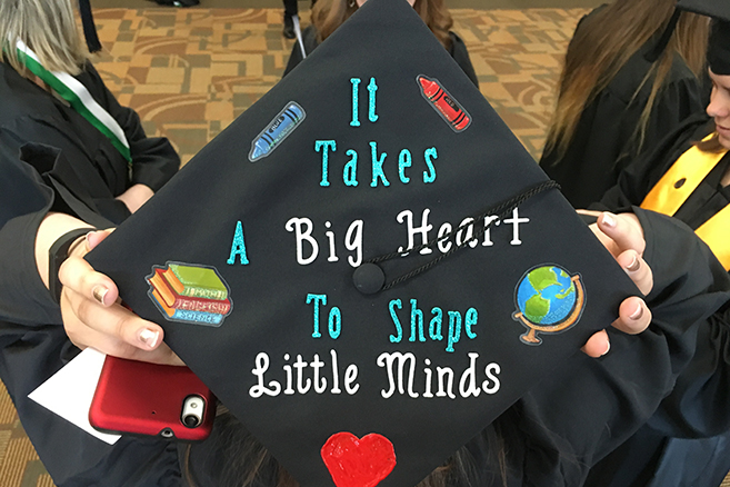 A graduation cap that says "It takes a big heart to shape little minds"