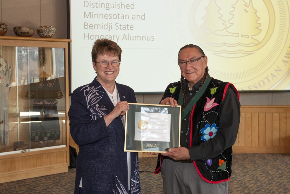 President Faith C. Hensrud presenting Arne Vainio with the 38th Distinguished Minnesotan plaque