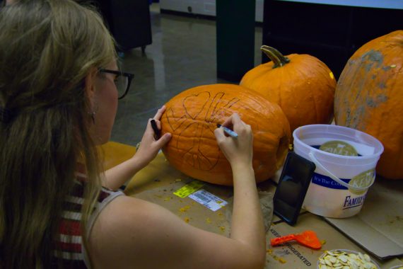 A student carves a pumpkins in Hobson Memorial Union