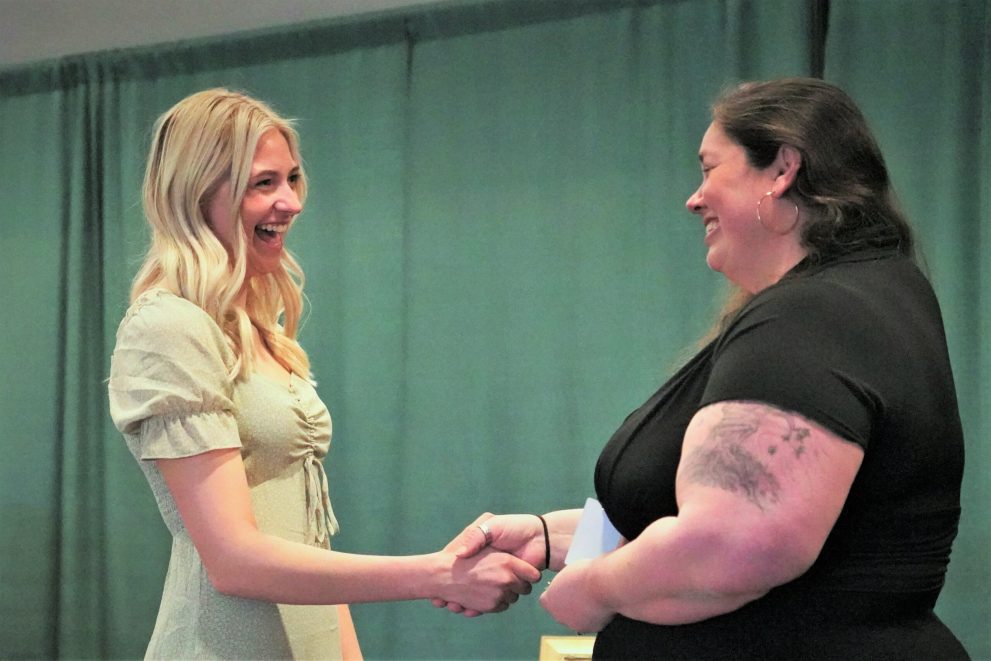 Faith Beck shakes hands with a BSU nursing faculty member