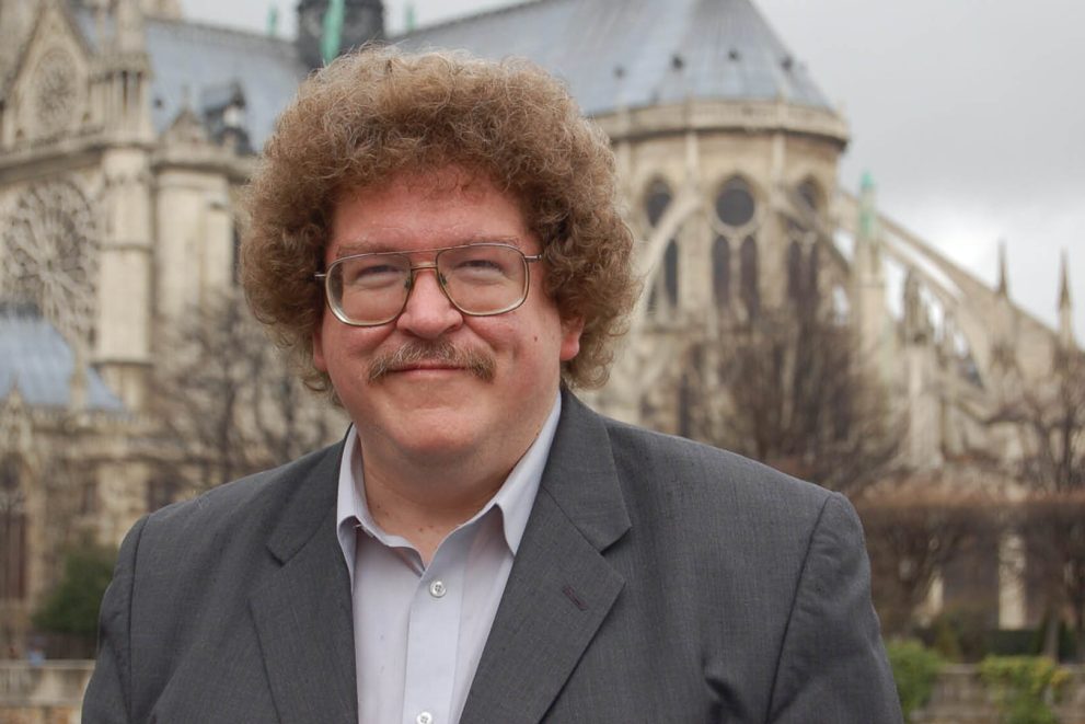 Eric Ewazen is standing in front of Notre Dame Cathedral in France