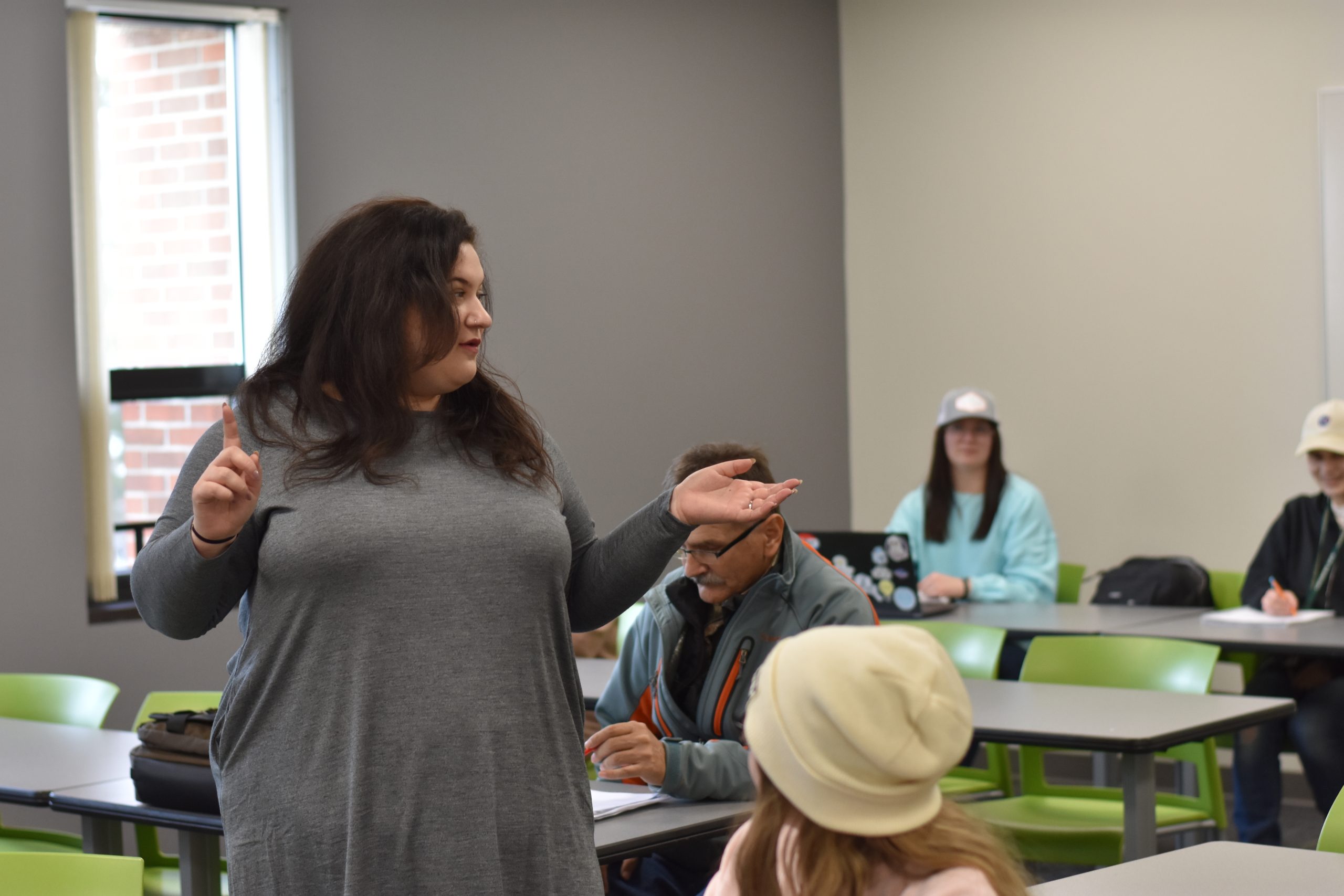 Judith Zatkin teaching a psychology class and standing between rows of students