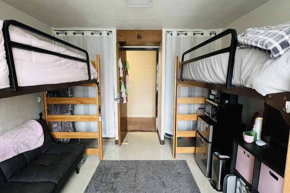 Tamarack double room with two lofted beds. Both closets have matching curtains and the door is open looking into the hallway.