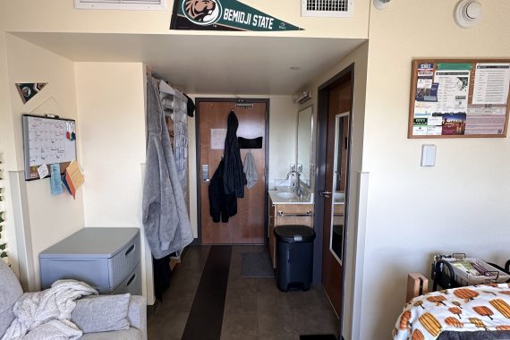 Linden suite room looking from the bedroom at the closet, hallway door, sink, and shared bathroom door.