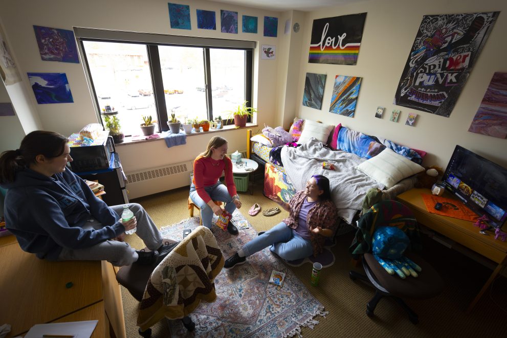 Three students sitting in a Birch Hall double-as-single room.